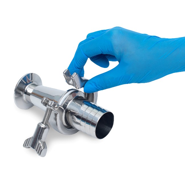 A close-up image of a hand wearing a blue disposable glove adjusting a stainless steel sanitary fitting. The fitting features a clamp and a barbed connection, commonly used in laboratory or industrial fluid transfer systems.